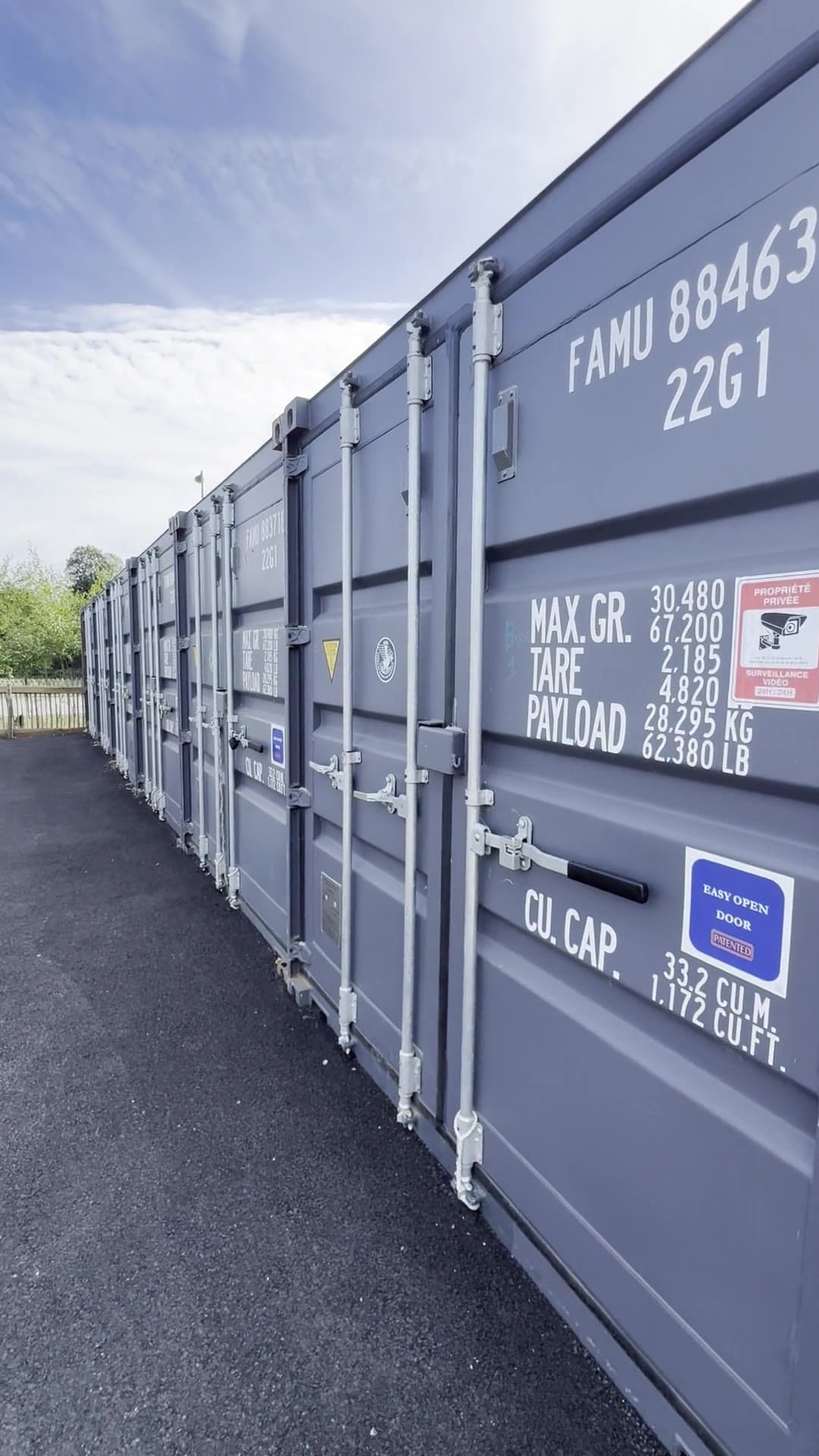 Alignement de conteneurs de stockage neufs sur une plateforme goudronnée, à Bourg-Blanc